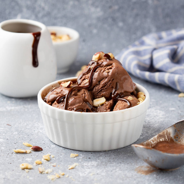Chocolate ice cream with sauce and nuts, delicious summer desser - Фото, зображення