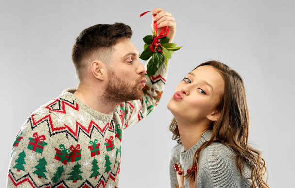 happy couple kissing under the mistletoe - Foto, afbeelding