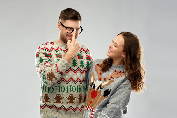 happy couple at christmas ugly sweater party - Foto, afbeelding
