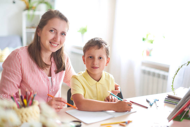 mother helps son to do lessons. home schooling, home lessons - Valokuva, kuva