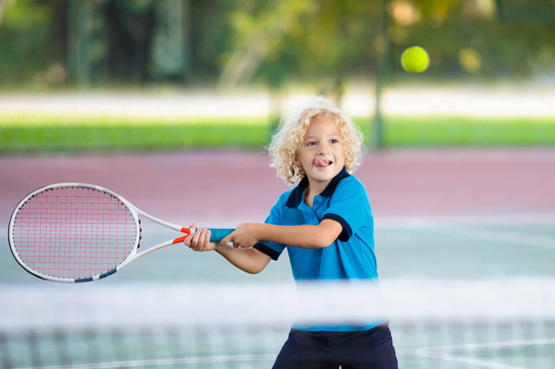 Child playing tennis on outdoor court - Photo, Image