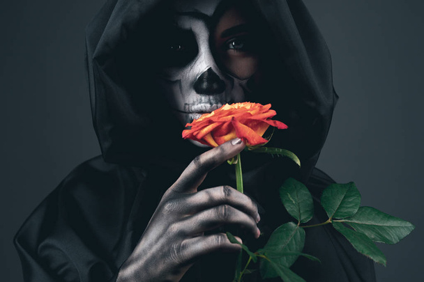 Creepy female in black cape with red rose - Photo, image