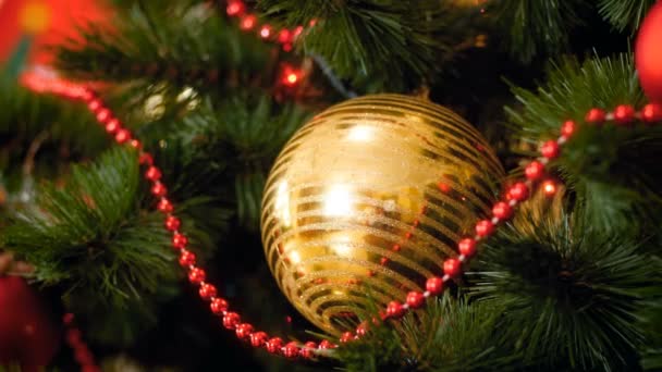 4k záběry z kamery pomalu oddalující vánoční stromek s barevnými věnci a cetkami. Perfektní záběr pro zimní oslavy a svátky - Záběry, video
