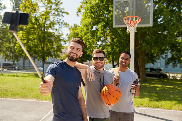 happy men taking selfie on basketball playground - Fotó, kép