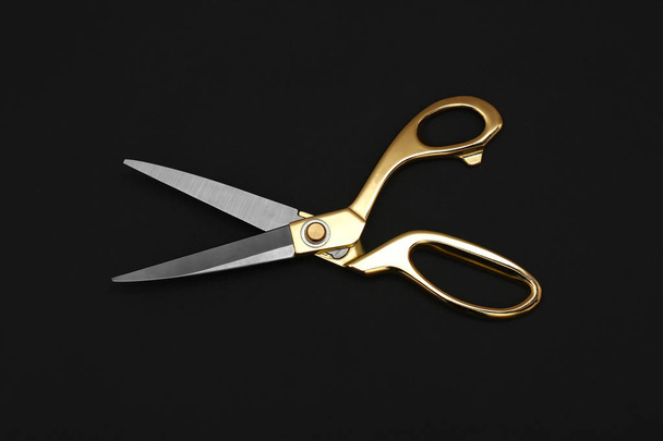 Gold tailor scissors on black background, top view - Foto, immagini