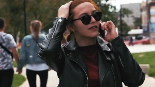 Young Woman Drinking Coffee on the Street, talking a Mobile Phone While Walking in an Urban Setting. - Filmmaterial, Video