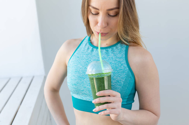 Healthy, sport, diet and people concept - Successful fitness urban woman recommending detox smoothie, close-up - Fotoğraf, Görsel