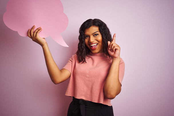 transsexuelle Transgender-Frau mit Sprechblase über isoliertem rosa Hintergrund überrascht mit Idee oder Frage, Zeigefinger mit glücklichem Gesicht, Nummer eins - Foto, Bild