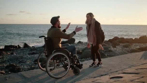 Disabled man with cheerful woman friend outdoors - Footage, Video