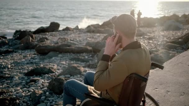 Homme handicapé parlant sur mobile sur le rivage
 - Séquence, vidéo