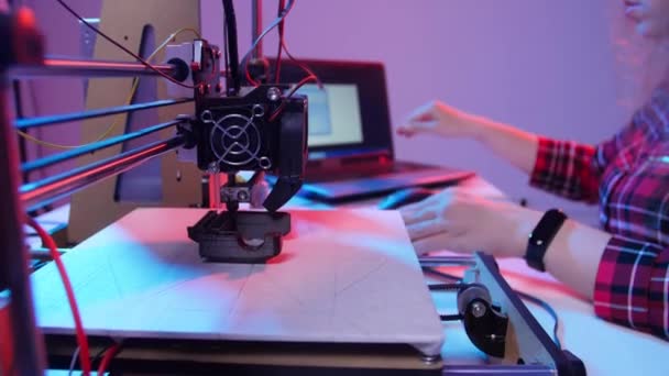 A modern gyártástechnológiák fogalma A fiatal hölgy 3D nyomtatón nyomtat egy modellt - Felvétel, videó