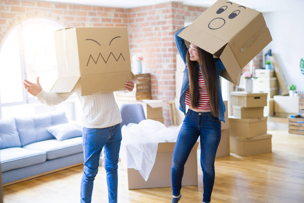 Τρελό ζευγάρι φορώντας κουτιά με αστεία πρόσωπα πάνω στο κεφάλι, έχοντας Fu - Φωτογραφία, εικόνα
