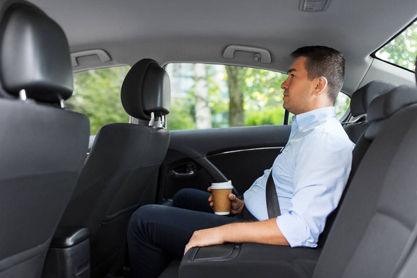 businessman with takeaway coffee on car back seat - Φωτογραφία, εικόνα
