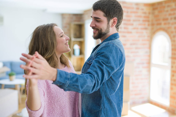 Young couple dancing celebrating moving to new apartment around  - Fotoğraf, Görsel