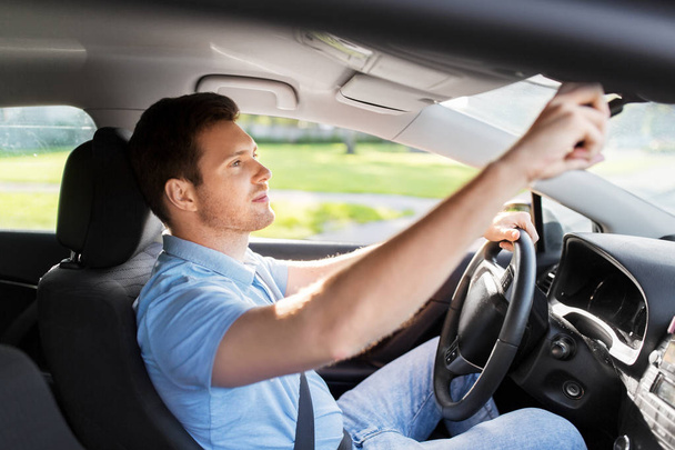 man or car driver adjusting mirror - Фото, зображення