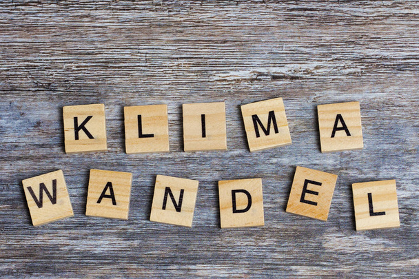 Německé slovo znamená změnu klimatu v angličtině, která je položených dřevěnými velkými písmeny na dřevěném pozadí - Fotografie, Obrázek