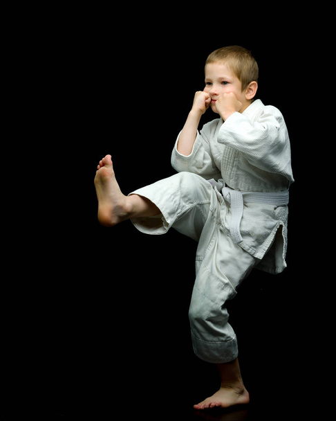 A little boy in a white kimono fulfills blows - Φωτογραφία, εικόνα