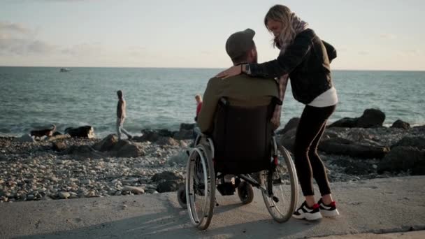 Nő ölelni szeretett fogyatékos férje a tengeren parton - Felvétel, videó