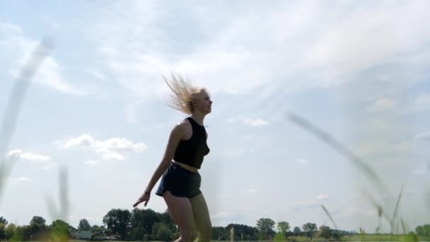 Χαμογελαστή κοπέλα που πηδάει σε τραμπολίνο και κάνει σπάγκο στον αέρα, αργή κίνηση - Πλάνα, βίντεο