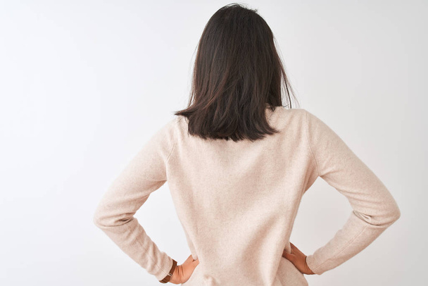 Beautiful chinese woman wearing turtleneck sweater standing over isolated white background standing backwards looking away with arms on body - Foto, immagini