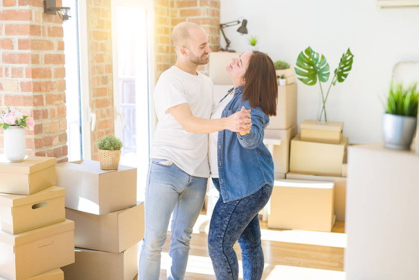 Nuori pari tanssimassa pahvilaatikoiden ympärillä uudessa kodissa, julkkis
 - Valokuva, kuva