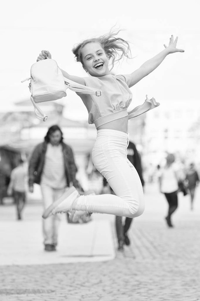 Her style is a lot more casual. Happy small girl jumping in casual and comfy outfit. Little cute child smiling in casual style. Casual and comfortable - Foto, afbeelding