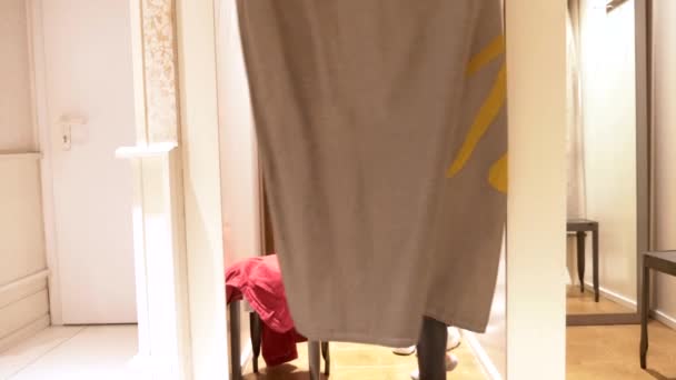 woman in a clothes fitting room. stylish bald woman comes out of the fitting room in leather leggings and a fashionable sweatshirt - Footage, Video