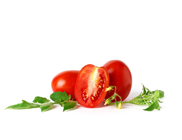 rijpe rode hele tomaten en plakjes op een witte achtergrond - Foto, afbeelding