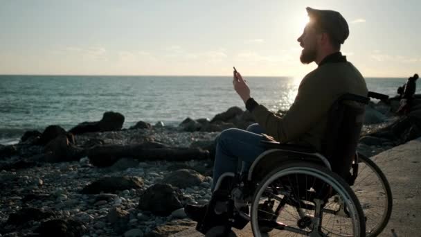 Hombre discapacitado que tiene chat de vídeo móvil al aire libre
 - Imágenes, Vídeo