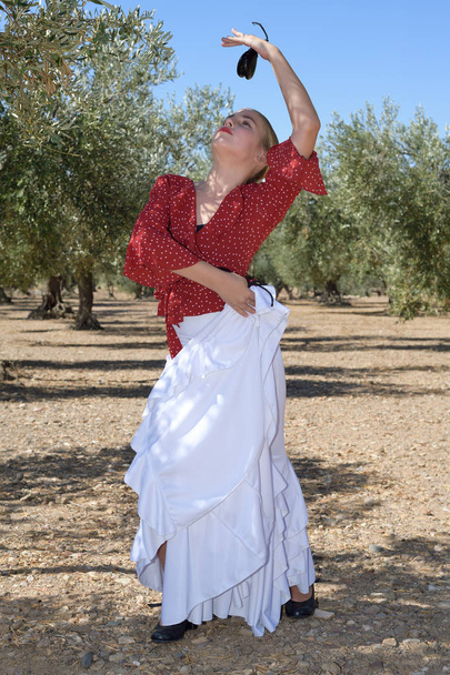 Girl in a flamenco position in an olive grove - Photo, Image