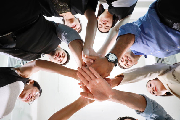 Gros plan sur les gens d'affaires multiethniques qui mettent leurs mains ensemble signification du concept de travail d'équipe
 - Photo, image