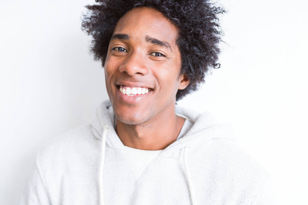 Bel homme afro-américain avec des cheveux afro sur fond blanc avec un sourire heureux et cool sur le visage. Personne chanceuse
. - Photo, image