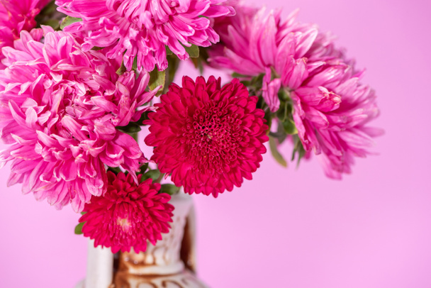 Beautiful bouquet of red flowers asters in a ceramic jug on a pi - Photo, Image