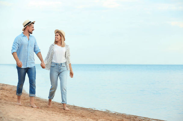 glückliches romantisches Paar, das am Strand spaziert, Platz für Text - Foto, Bild