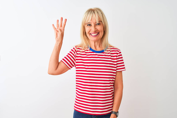 Middle age woman wearing casual striped t-shirt standing over isolated white background showing and pointing up with fingers number four while smiling confident and happy. - Photo, Image