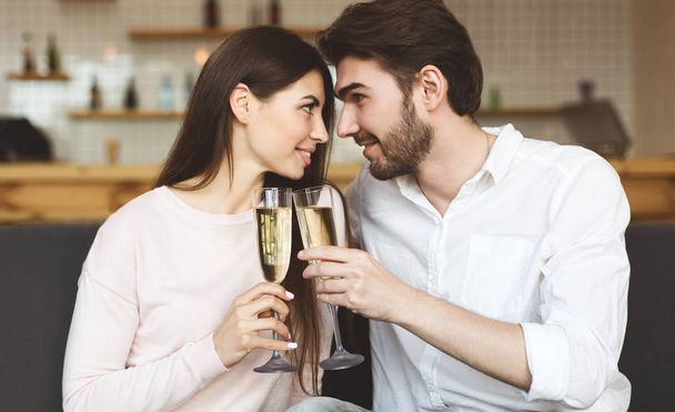 Влюбленная пара пьет шампанское и смотрит друг на друга
 - Фото, изображение