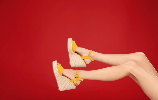 Woman in stylish shoes on red background - Fotoğraf, Görsel