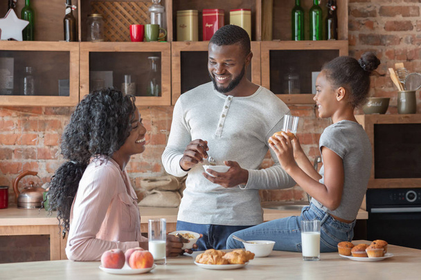 Szép család beszélgetés közben reggelizni a konyhában - Fotó, kép