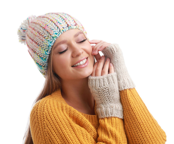 Young woman in warm sweater, mittens and hat on white background. Winter season - Фото, зображення