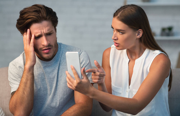Wife Showing Cheating Husband Cellphone Demanding Explanation At Home - Valokuva, kuva