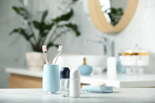 Roll-on deodorants with toiletry on table in bathroom, space for text - Photo, image