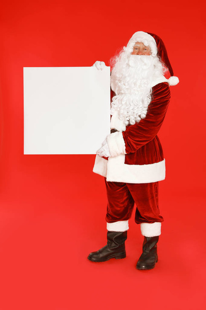 Authentic Santa Claus with blank banner on red background. Space for design - Photo, Image