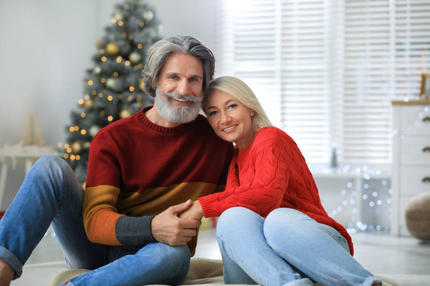 Happy mature couple celebrating Christmas at home - Фото, изображение