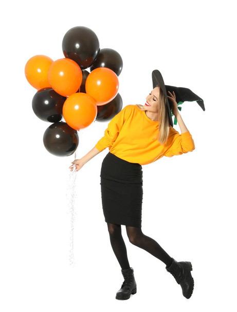 Beautiful woman wearing witch costume with balloons for Halloween party on white background - Foto, afbeelding