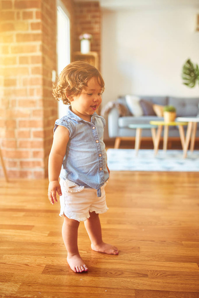 Όμορφο μικρό κοριτσάκι φορώντας μπλε πουκάμισο denim στέκεται στο πάτωμα - Φωτογραφία, εικόνα