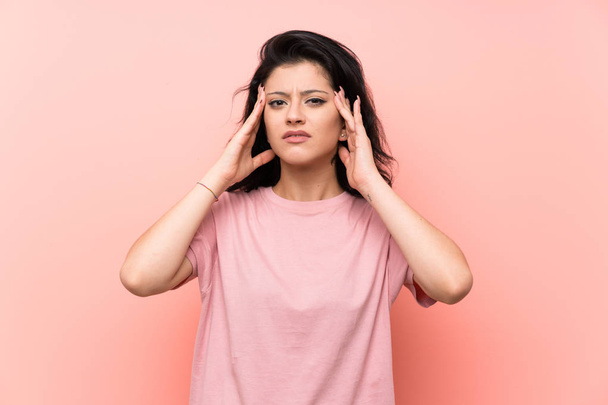 Young woman over isolated pink background unhappy and frustrated with something. Negative facial expression - Photo, image