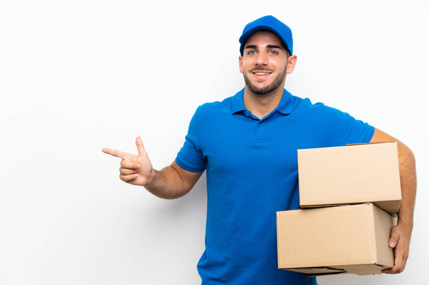 Delivery man over isolated white background pointing finger to the side - Photo, Image