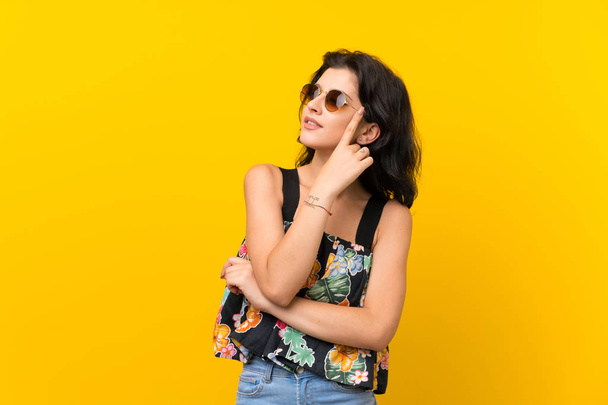 Young woman over isolated yellow background with glasses - Photo, Image
