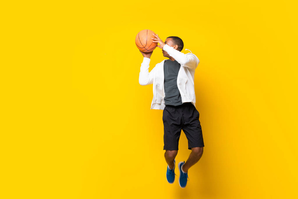 Αφρο-Αμερικανός μπασκετμπολίστας πάνω από απομονωμένο κίτρινο backgro - Φωτογραφία, εικόνα