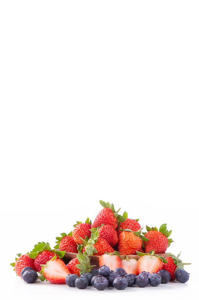 Un cuenco de hermosas y deliciosas fresas y arándanos aislados sobre fondo blanco, de cerca, espacio para copiar, recortar camino, cortar
. - Foto, Imagen